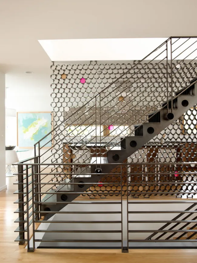 Дизайнерский ход для зонирования открытого пространства в доме: металлическая лестница и межкомнатная перегородка 