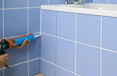 Рабочий процесс – укладывает плитку в ванной своими руками