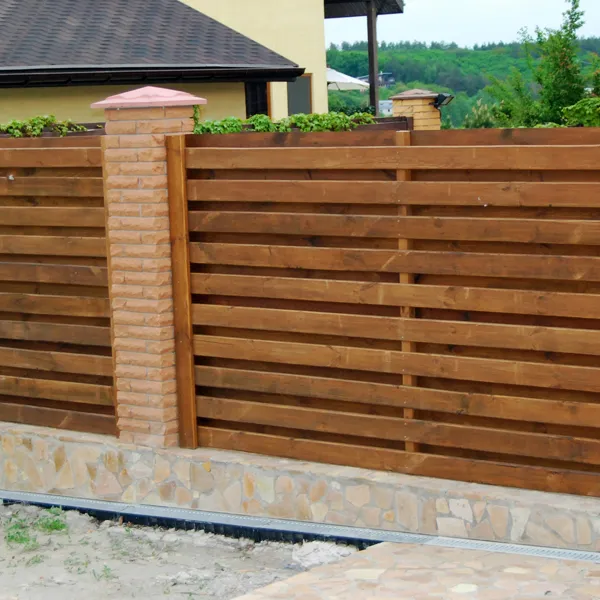 деревянный горизонтальный забор с кирпичными столбами